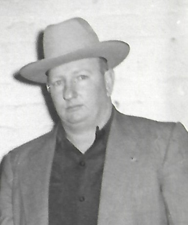 Portrait of Raymond Harper, a law enforcement figure in Pensacola, wearing a hat and suit, with a serious expression.