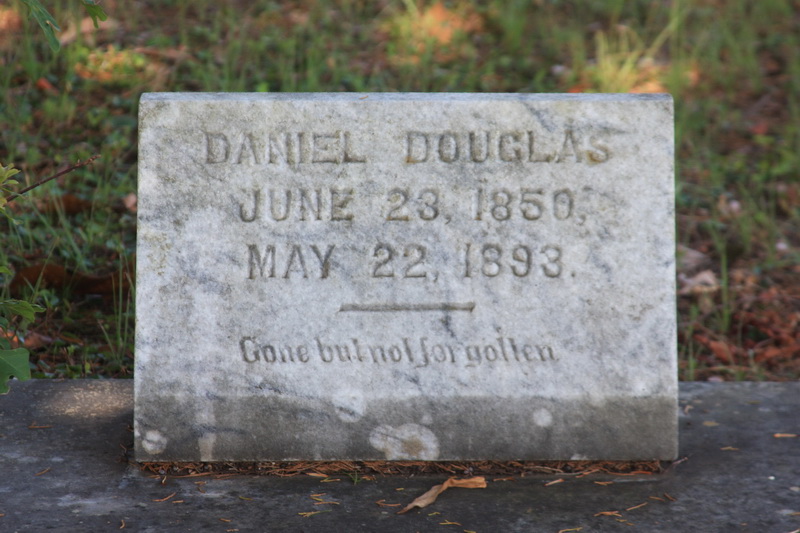 Grave marker of Daniel Douglas, inscribed with his birth and death dates: June 23, 1850, and May 22, 1893, along with the epitaph 'Gone but not forgotten'.