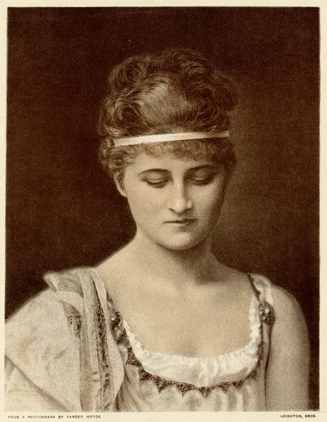 A sepia-toned portrait of a young woman with wavy hair styled with a headband, wearing a classical outfit with a delicate semblance. She gazes downward, conveying a sense of introspection.