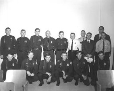 Black and white photo of a group of early law enforcement trainees and instructors posing for a picture at Pensacola Junior College.