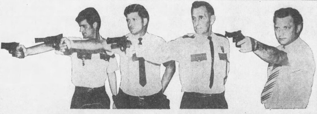 Four law enforcement trainees pointing handguns during a training exercise.