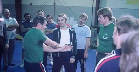Historical photo of a law enforcement training class at Pensacola Junior College, featuring an instructor demonstrating techniques to a group of students in a gymnasium setting.