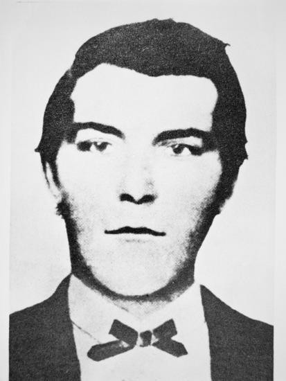 Black and white portrait of a young man with a bowtie, showing a neutral expression.