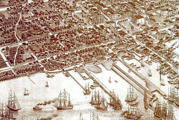 Detailed aerial view of a historical port city, featuring numerous ships in the harbor, buildings, streets, and green spaces, all depicted in a sepia tone.